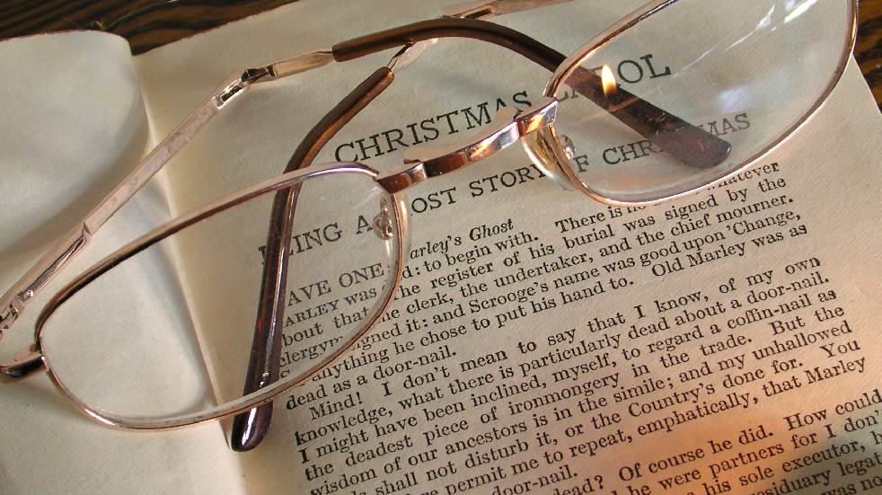 reading glasses on top of a Christmas Carol book